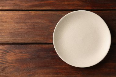 Ahşap masada boş seramik tabak, üst manzara. Metin için boşluk
