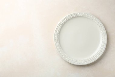 Empty ceramic plate on white table, top view. Space for text
