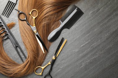 Gri arka planda güzel saç teli ve kuaför aletleri var. Metin için boşluk