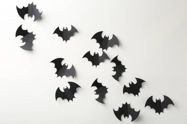 Cadılar Bayramı dekoru. Beyaz zemin üzerinde siyah kağıt yarasalar, düz yatıyordu