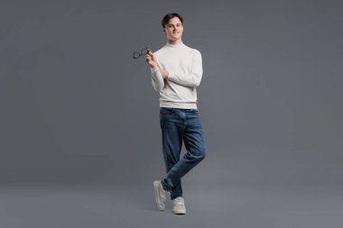 Gri arka planda şık kotlu adam.