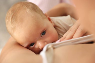 Anne yeni doğmuş bebeğini evde emziriyor.