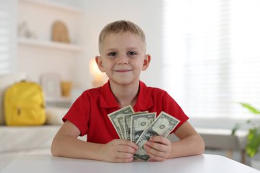 Beyaz masada cep harçlığı tutan küçük çocuk.