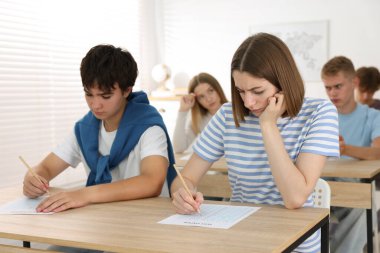 Ahşap masada sınava giren öğrenciler