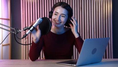 Podcast sunucusu stüdyoda talk show kaydediyor.