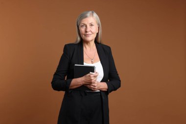 Kahverengi arka planda not defteri ve kalemi olan profesyonel psikoterapist.