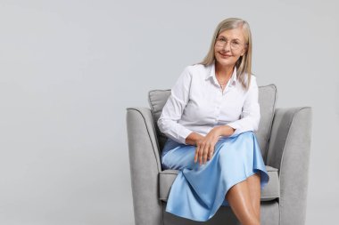 Açık gri arka planda koltukta profesyonel psikoterapist, metin için boşluk