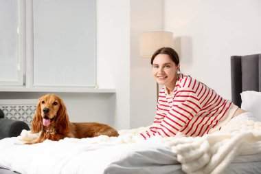 Evcil hayvan dostu otel. Kadın ve sevimli köpeği yatağın içinde