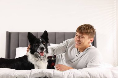 Evcil hayvan dostu otel. Bir adam ve sevimli köpeği yatağın içinde