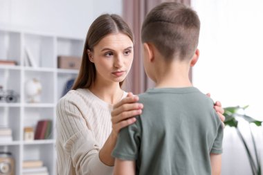 Anne, üzgün oğlunu evde destekliyor.