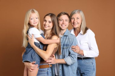 Kahverengi arka planda oğlu ve ailesi olan yaşlı bir kadının portresi.