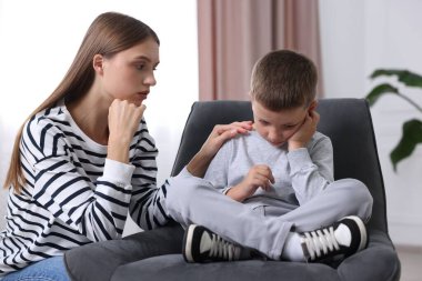 Anne, üzgün oğlunu evde destekliyor.