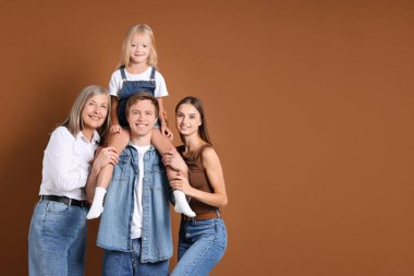 Kahverengi arka planda oğlu ve ailesi olan yaşlı bir kadının portresi. Metin için boşluk