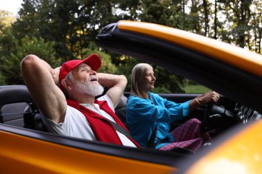 Üst düzey bir çift açık havada eğleniyor, seçici bir odak noktası var.