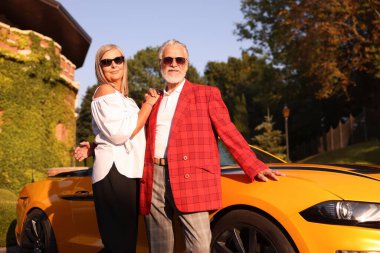 Modern Cabriolet yakınlarında güneş gözlüklü şık bir çift.