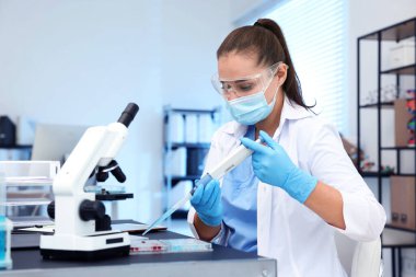 Genetik araştırması. Laboratuvarda çalışan mikro pipet ve mikro plakalı bir bilim adamı.