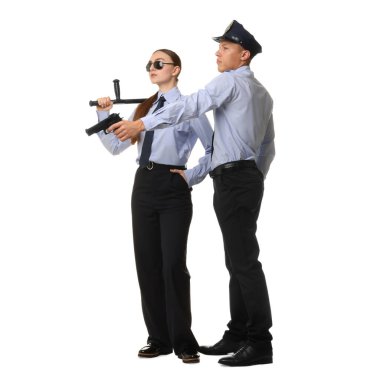 Beyaz arka planda copu ve silahı olan genç bir kadın polis ve polis.