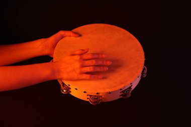 Siyah arkaplanda tef çalan kadın, yakın plan