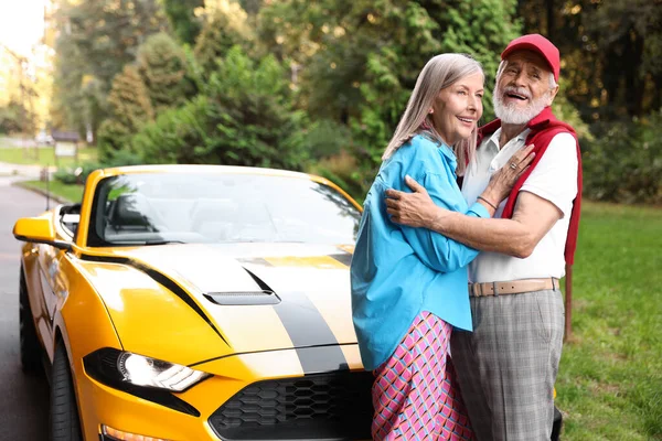 Modern Cabriolet yakınlarında şık bir yaşlı çift.
