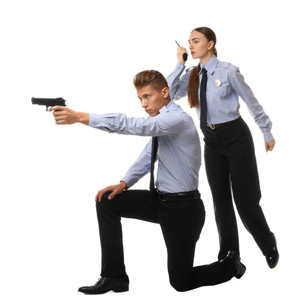Young policewoman and policeman with walkie talkie and gun on white background