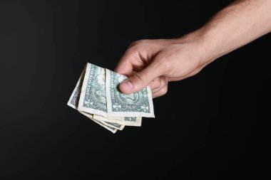 Siyah arka planda dolar banknotları olan adam, yakın plan.