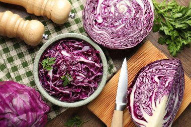 Fresh red cabbages, parsley and knife on wooden table, flat lay