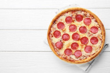 Beyaz ahşap arka planda nefis pepperoni pizza, üst manzara. Metin için boşluk