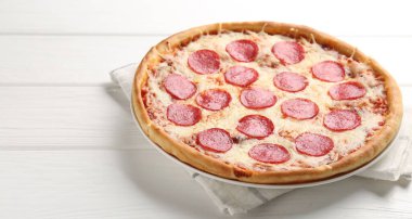 Delicious pepperoni pizza on white wooden background, closeup. Space for text