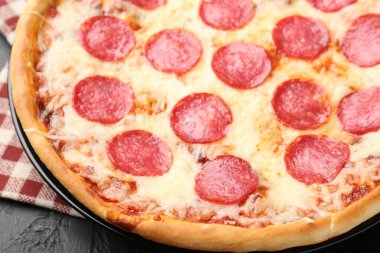 Siyah arka planda nefis biberli pizza, yakın plan.