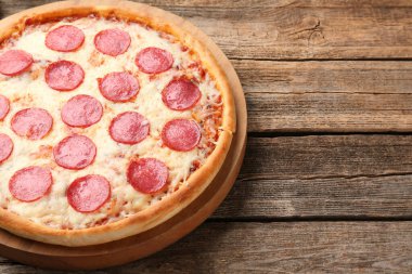 Delicious pepperoni pizza on wooden table, closeup. Space for text