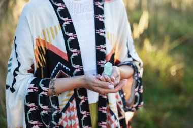 Kadın dışarıda atmosferini iyileştirmek ya da iyileştirmek için kristalle meditasyon yapıyor. Metin için boşluk