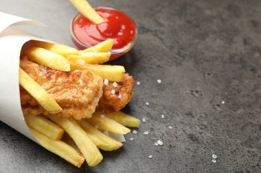 British Traditional Fish and chips with sauce on grey table, closeup. Space for text