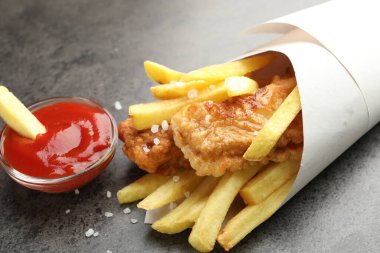 British Traditional Fish and chips with sauce on grey table, closeup