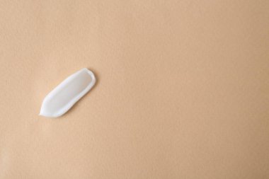 Bej arka planda nemlendirici krem örneği, üst manzara. Metin için boşluk