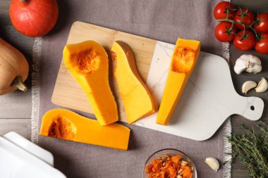 Cut pumpkin and ingredients on wooden table, flat lay