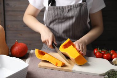 Masada taze balkabağı kesen kadın, yakın plan.