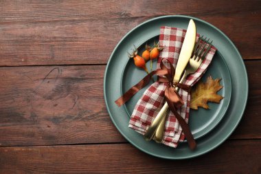 Beautiful table setting with autumn decor on wooden background, top view. Space for text