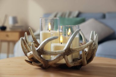Decorative LED candles on wooden table indoors, closeup