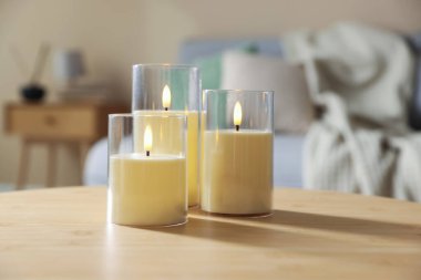 Decorative LED candles on wooden table indoors