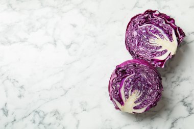Cut red cabbage on white marble table, top view. Space for text