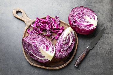 Kırmızıyı kes lahana ve bıçağı gri masaya koy, düz yat