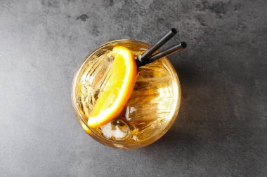 Glass of tasty cocktail on grey table, top view