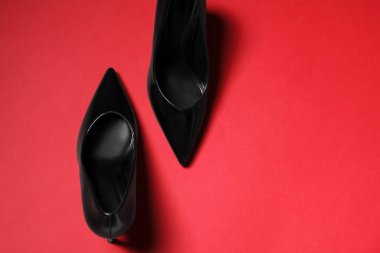 Pair of stylish high heeled shoes on red background, flat lay. Space for text