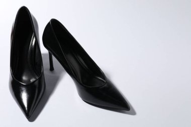 Pair of stylish high heeled shoes on light background, closeup. Space for text