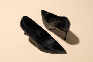 Pair of stylish high heeled shoes on beige background, closeup
