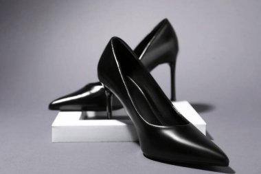 Pair of stylish high heeled shoes on gray background, closeup