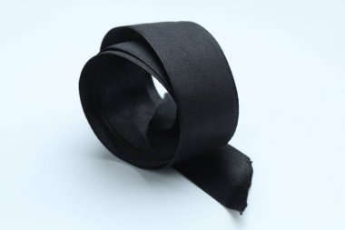 Beautiful black ribbon on white background, closeup