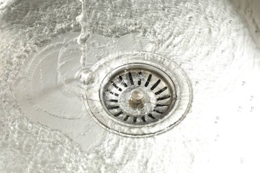 Water going down sink drain, closeup view