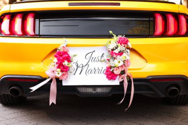 Düğün arabası. Cabriolet dekore edilmiş. Sadece evlilik kartı ve açık havada güzel çiçekler, yakın plan.