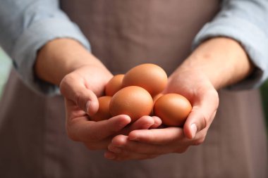 Bir sürü çiğ tavuk yumurtası olan adam, yakın plan.